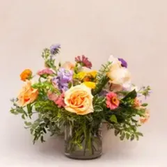 Peach and coral roses in a glass vase